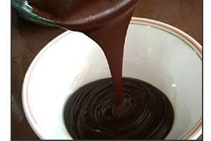 Ilustración de Colocar el baño de chocolate a los conitos de dulce de leche sin que se deformen